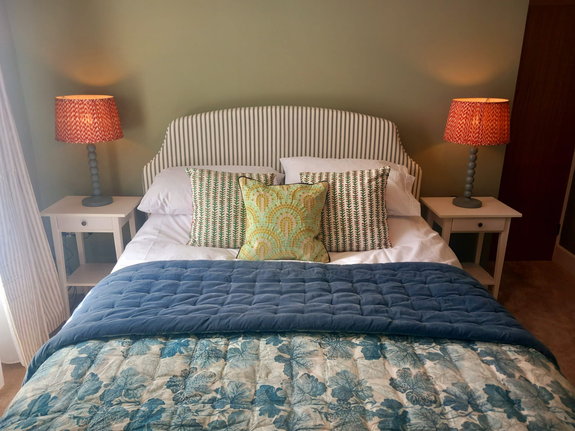 King-size double bedroom with striped headboard and blue throw